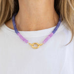 Model wearing a purple resin bead necklace in two different shades of purple with a large gold carabiner clasp at its center.