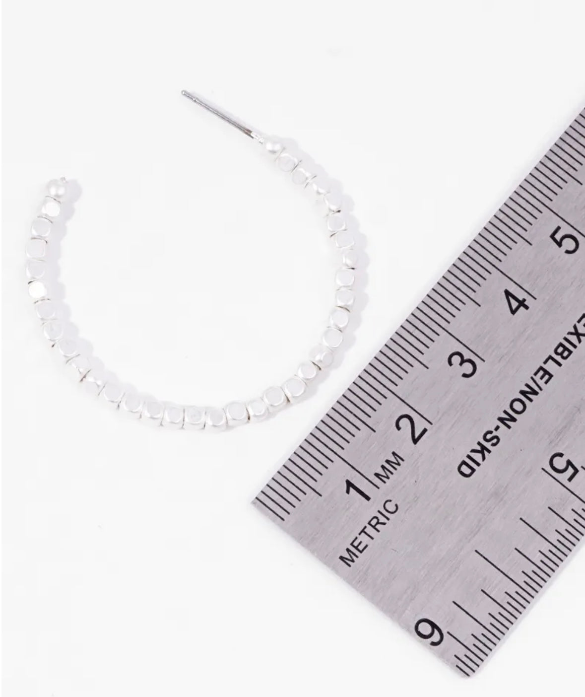 Picture of a white bead hoop earring next to a ruler showing the size to be 3.5cm.