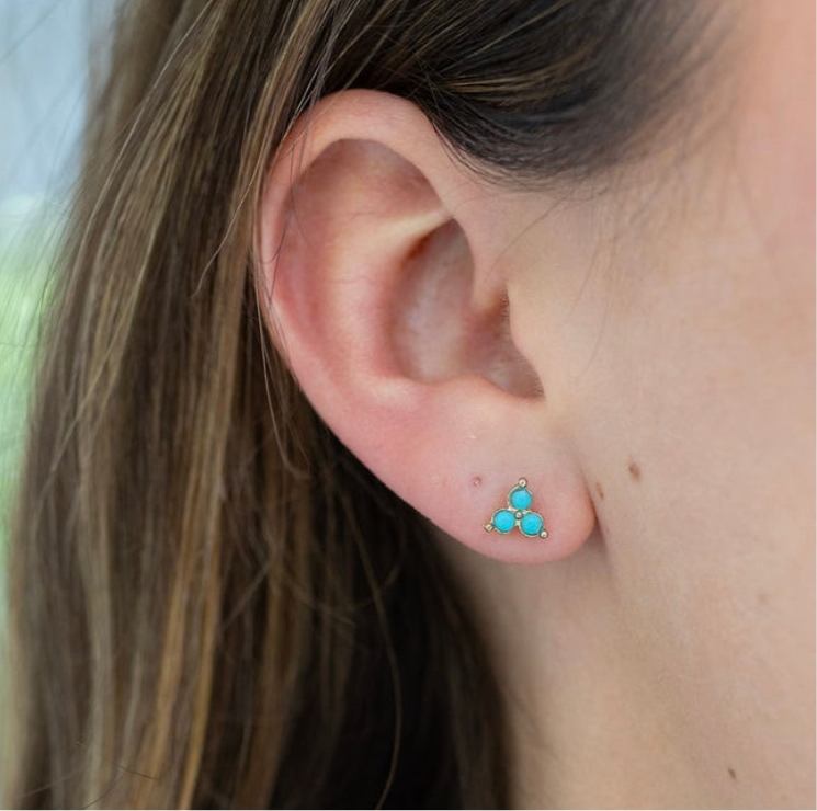 Picture of a model's ear displaying a three stone turquoise stone stud earrings.