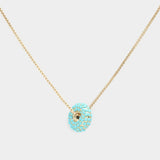 Turquoise donut shaped pendant necklace on a light background