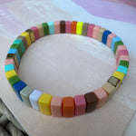 Bead bracelet in muted colors of coral, orange, browns, greens and blues.