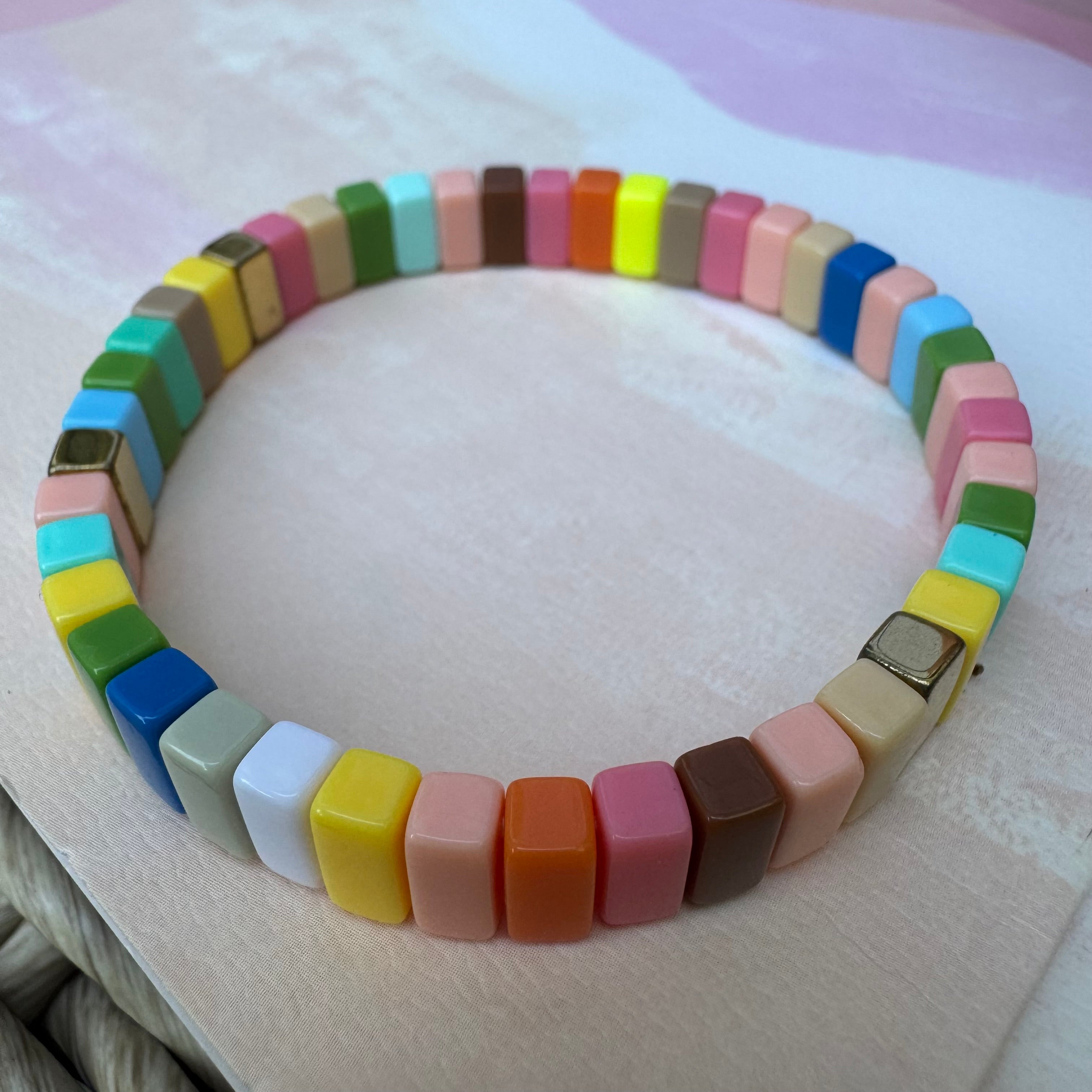 Bead bracelet in muted colors of coral, orange, browns, greens and blues.
