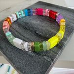 Picture of a colorful beaded bracelet in yellows, reds, purples, greens, whites and coral.