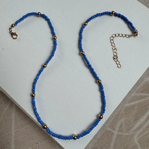 Picture of a dark blue seed bead necklace with gold accent beads 