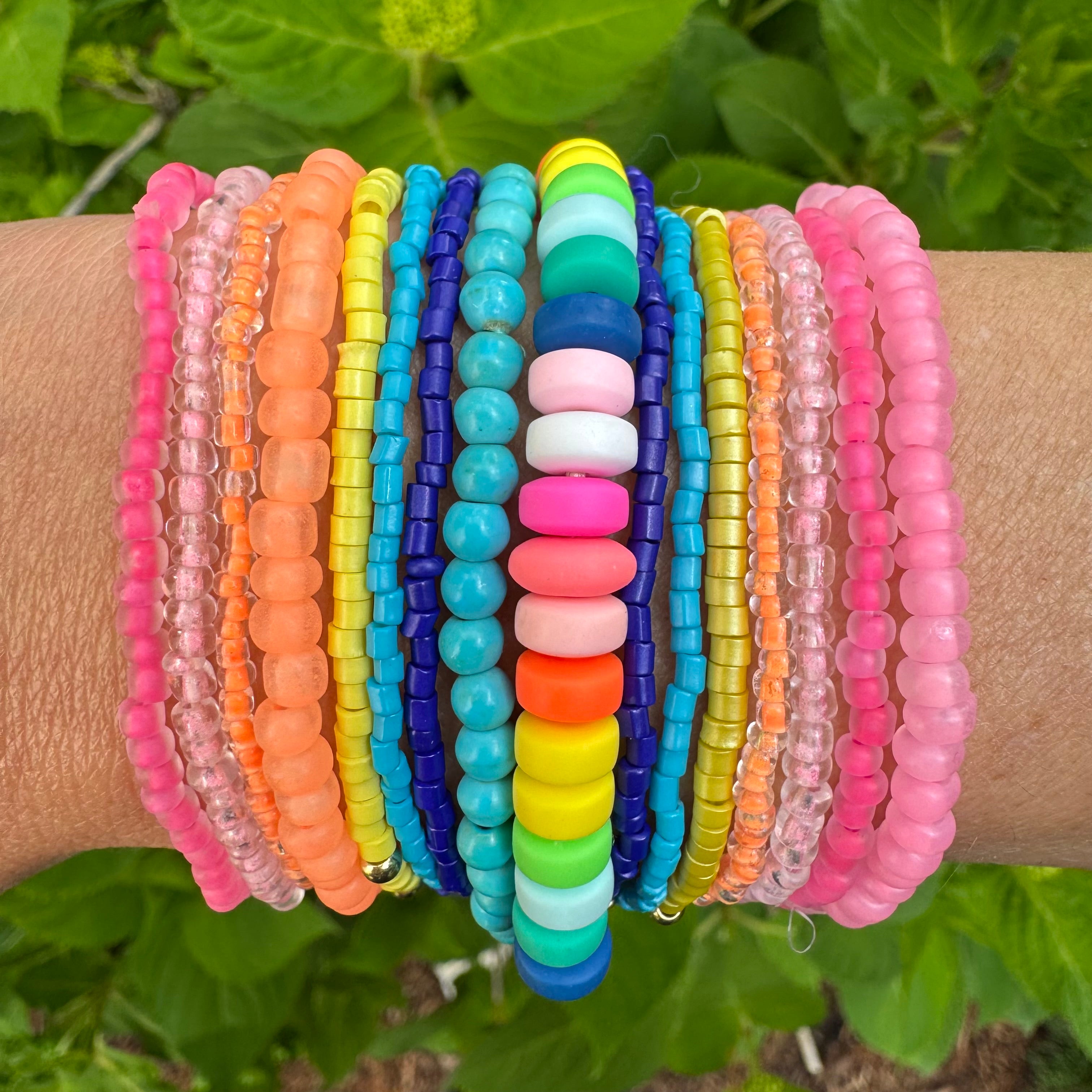 Beautiful set of 16 beaded bracelets. Bracelets are pink, orange, blue, turquoise, yellow and multicolored.
