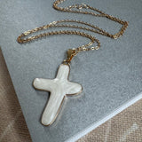 Gold chain with a large white cross.