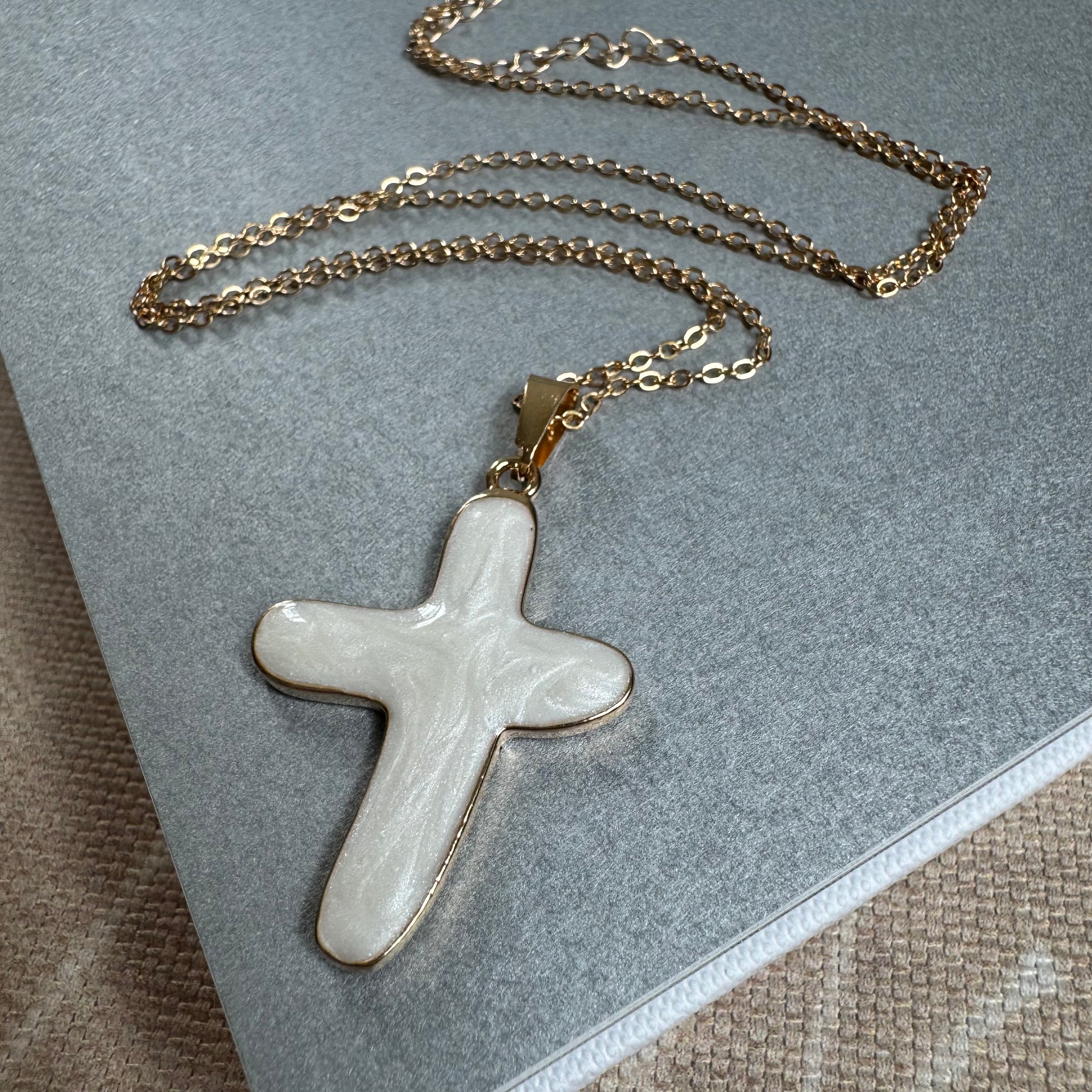 Gold chain with a large white cross.