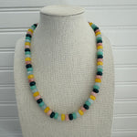 Picture of a necklace made of green, blue, white, yellow and pink beads with a large gold carabiner clasp.