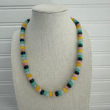 Picture of a necklace made of green, blue, white, yellow and pink beads with a large gold carabiner clasp.