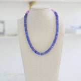 Picture of a blue resin bead necklace with a section of purple beads.