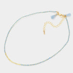Dainty bead necklace in colors of light blue and gold.