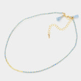 Dainty bead necklace in colors of light blue and gold.