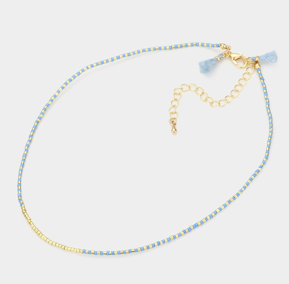 Dainty bead necklace in colors of light blue and gold.