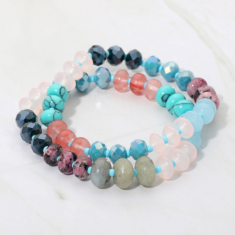 Colorful beaded bracelet in blues and pinks on a white background