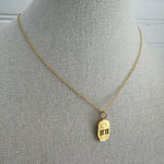 Picture of a dainty gold chain and an 11:11 gold charm
