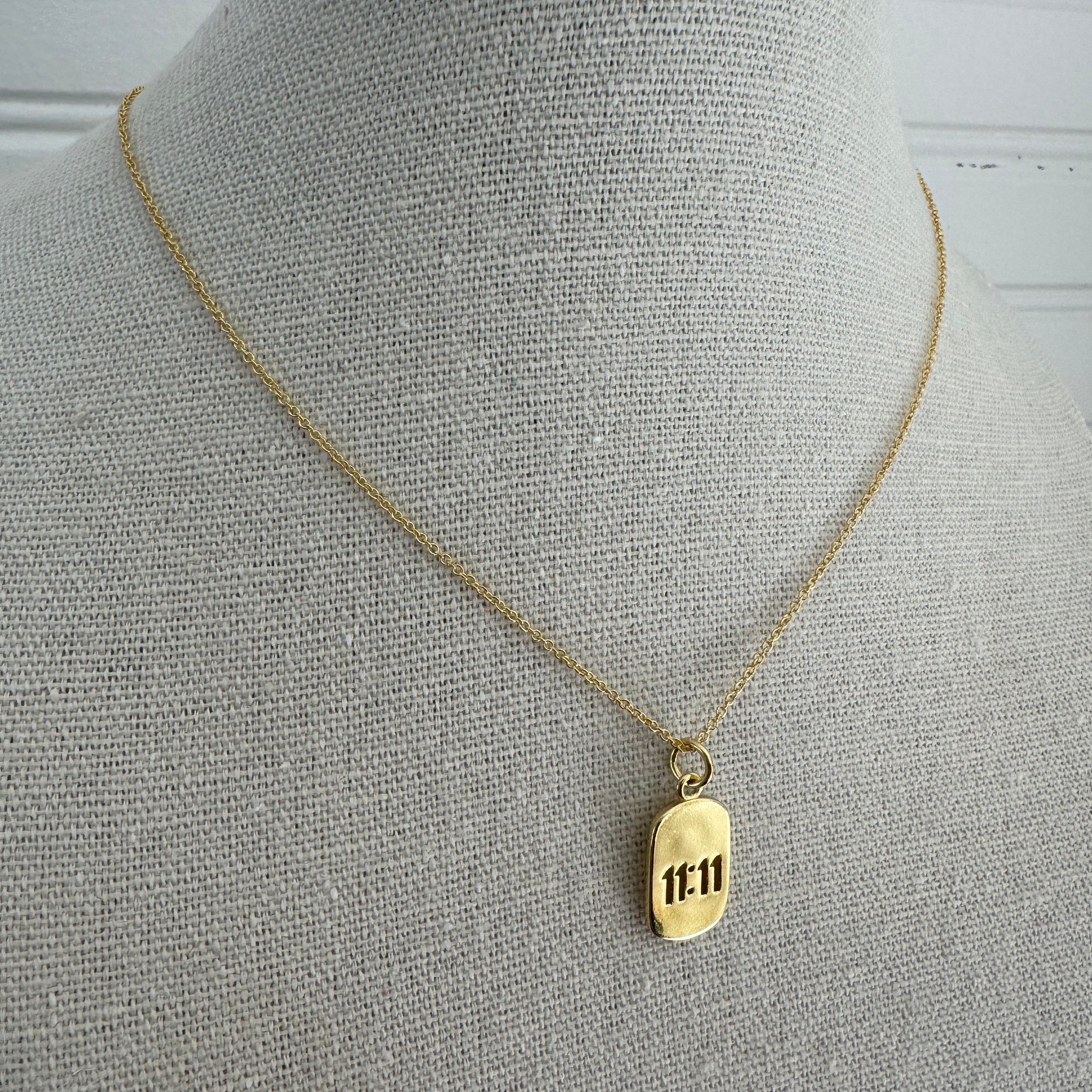 Picture of a dainty gold chain and an 11:11 gold charm