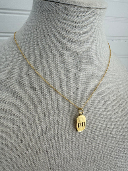 Picture of a dainty gold chain and an 11:11 gold charm