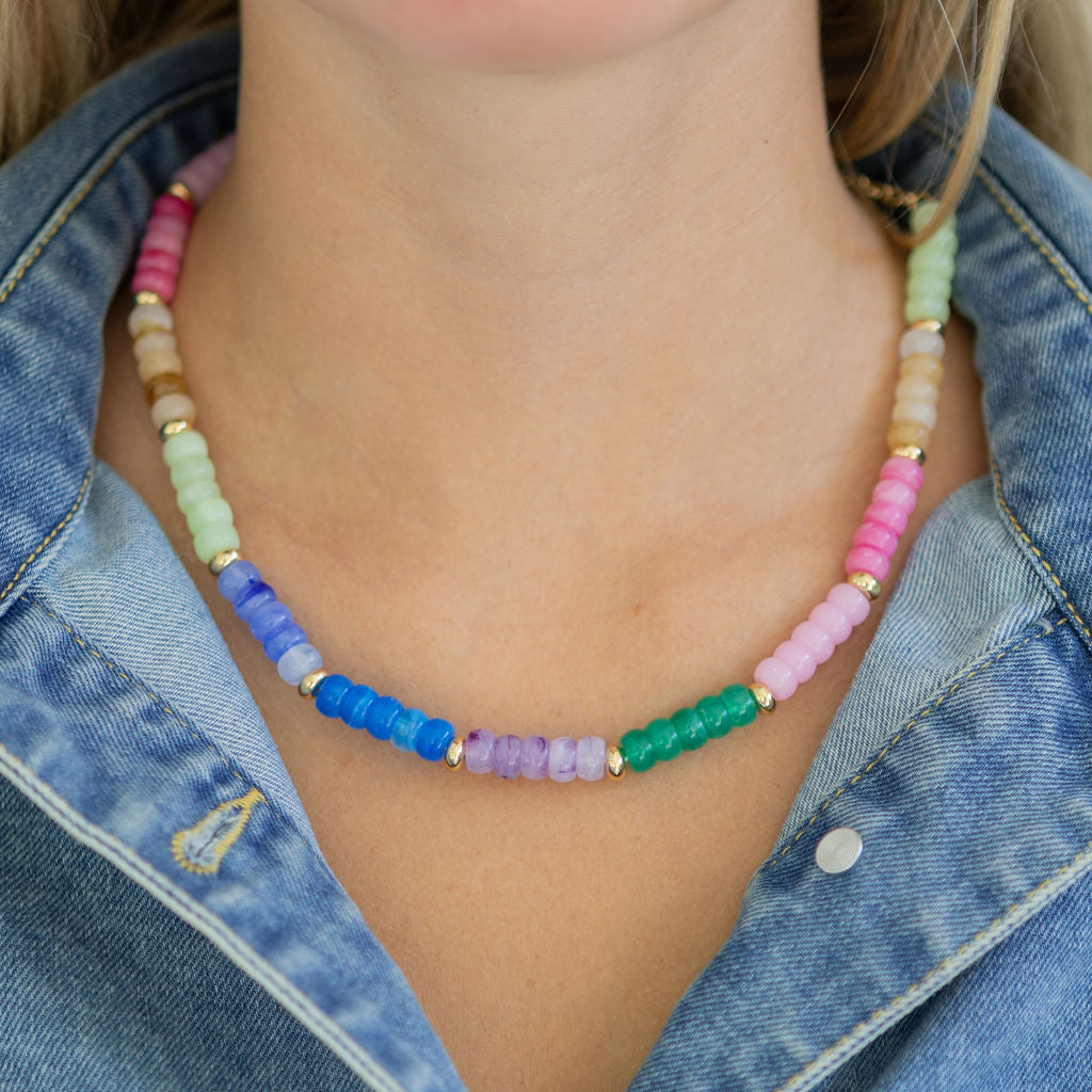 Colorful beaded necklace worn by a person with a denim top