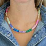 Colorful beaded necklace worn by a person with a denim top