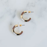 Small gold hoops with white and light brown resin accent sections.