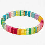 Multicolored bracelet made out of rectangle beads that vary between clear and solid color of reds, yellows, greens and blues.