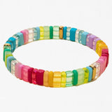 Multicolored bracelet made out of rectangle beads that vary between clear and solid color of reds, yellows, greens and blues.