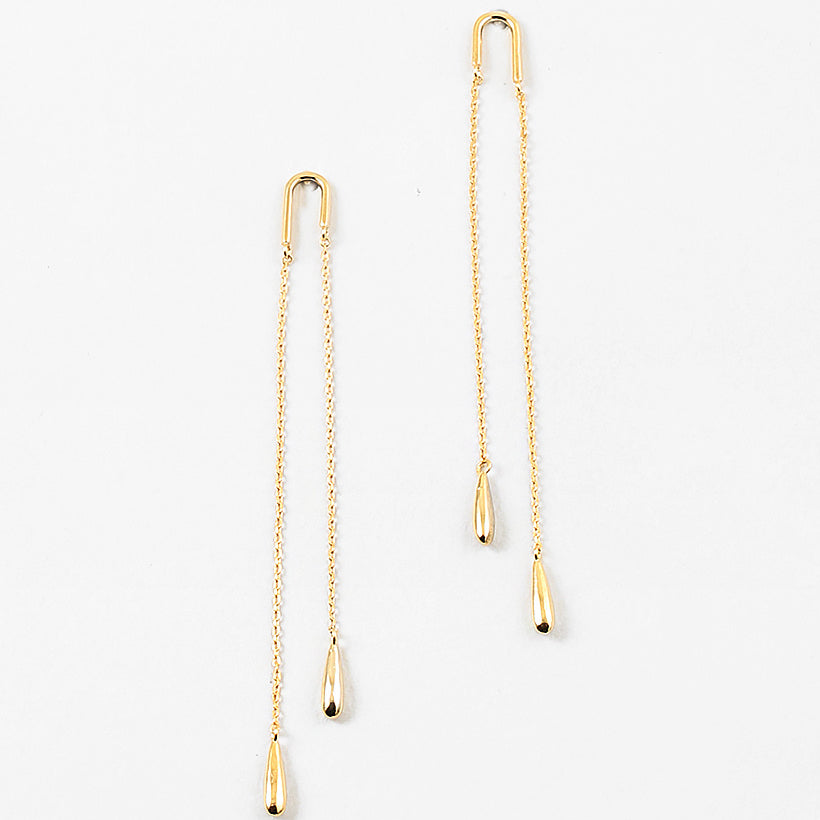 Gold chain threader earrings with teardrop pendants on a white background