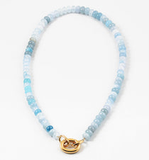 Necklace with light blue and white beads and a gold clasp on a white background