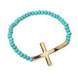 Turquoise beaded bracelet with a gold cross charm on a white background