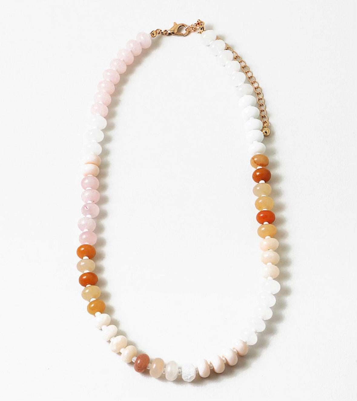 Picture of a beaded necklace in light pink, whites and oranges