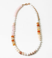 Picture of a beaded necklace in light pink, whites and oranges