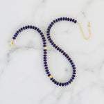 Picture of a necklace with dark blue beads, red spacer beads and gold accent beads