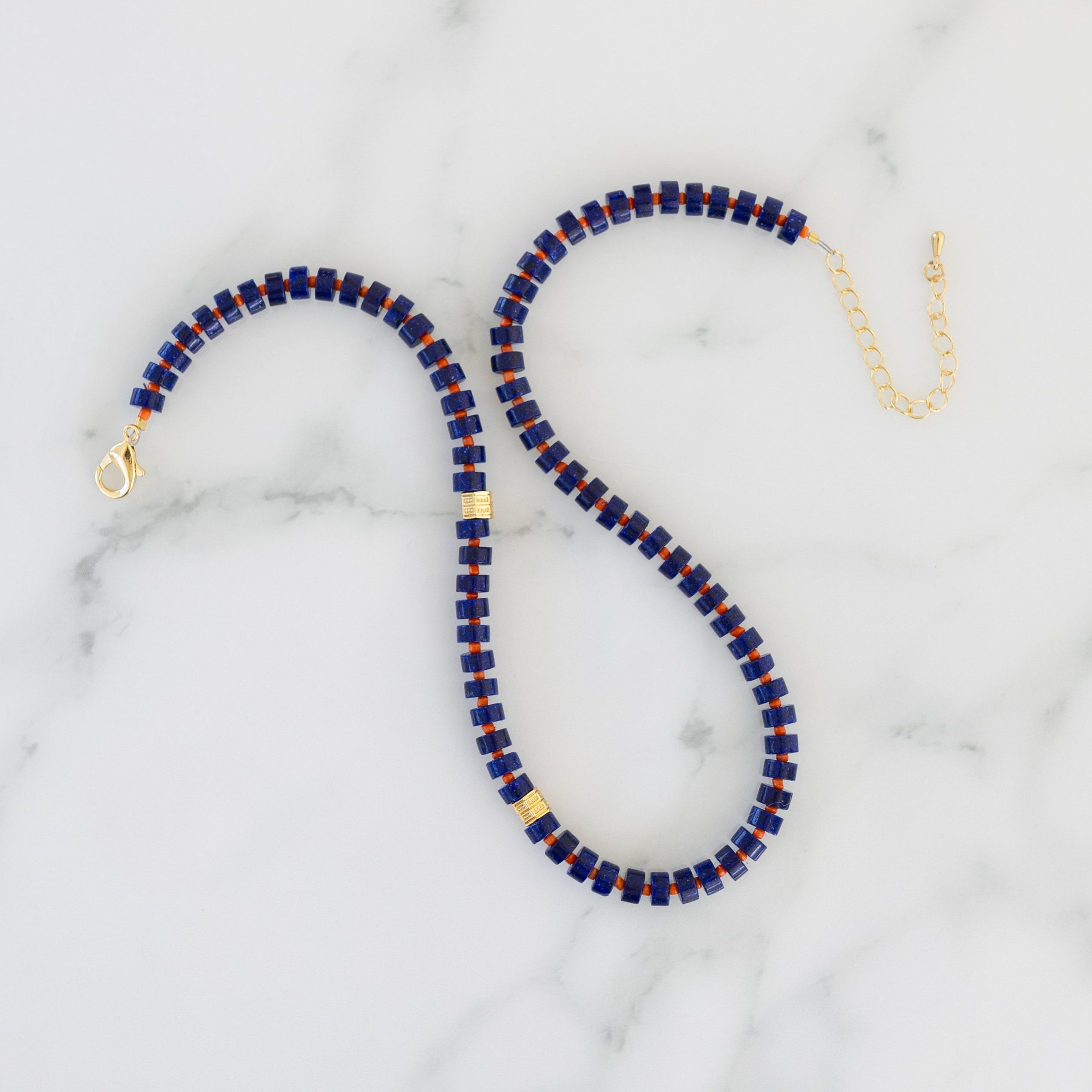 Picture of a necklace with dark blue beads, red spacer beads and gold accent beads