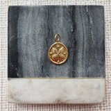 Picture of a gold disc pendant with a butterfly design.