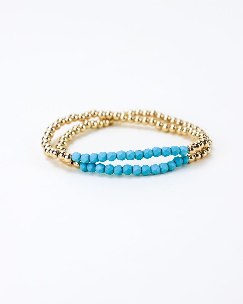 Set of two gold bead bracelets with a section of light blue beads.