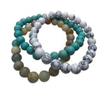 Set of three beaded bracelets with turquoise, white, and gray stones on a white background