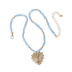 Necklace with light blue beads and gold heart-shaped pendant on a white background