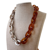 Dual toned chunky chain necklace in amber and white marble on a mannequin bust.