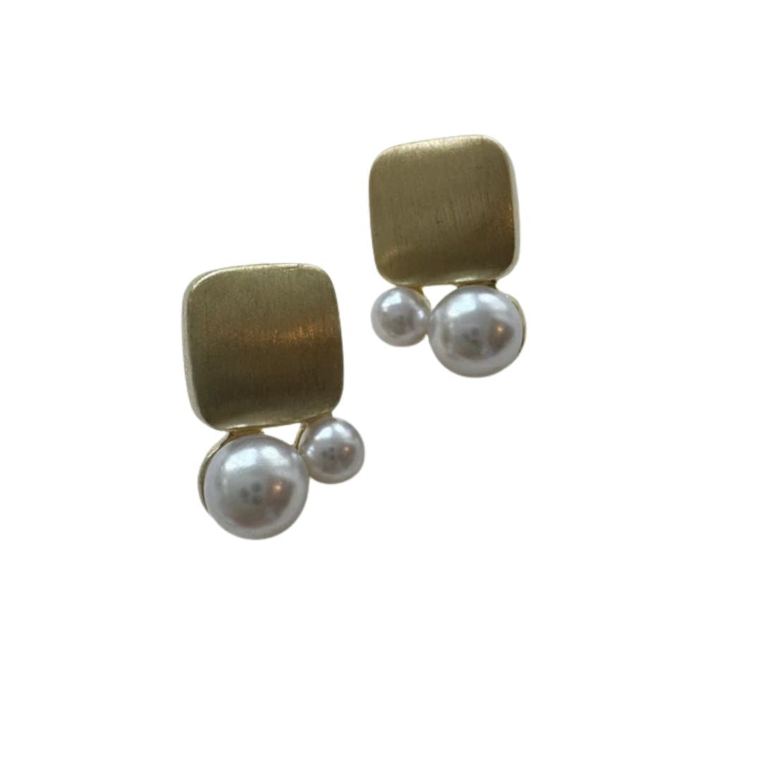 Gold and pearl geometric earrings on a white background