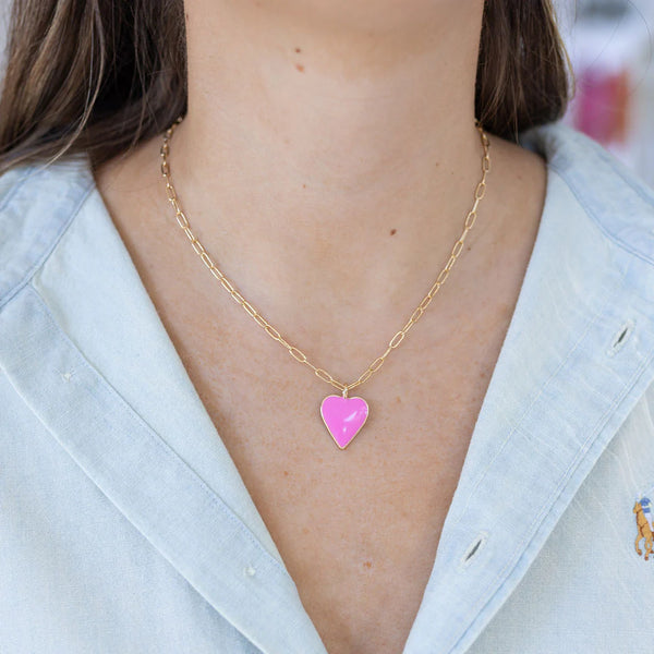 Model wearing a fine rectangle link chain with a pink enamel heart pendant.