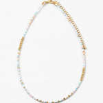Delicate bead necklace made of white, gold and light blue beads.