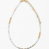 Delicate bead necklace made of white, gold and light blue beads.