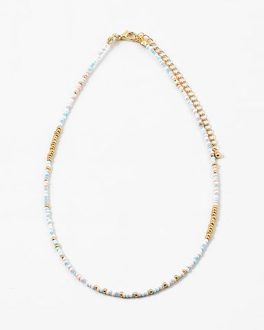 Delicate bead necklace made of white, gold and light blue beads.